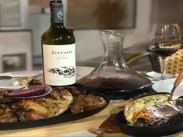 Carne a la parrilla argentina servida con vino tinto en Ocampo